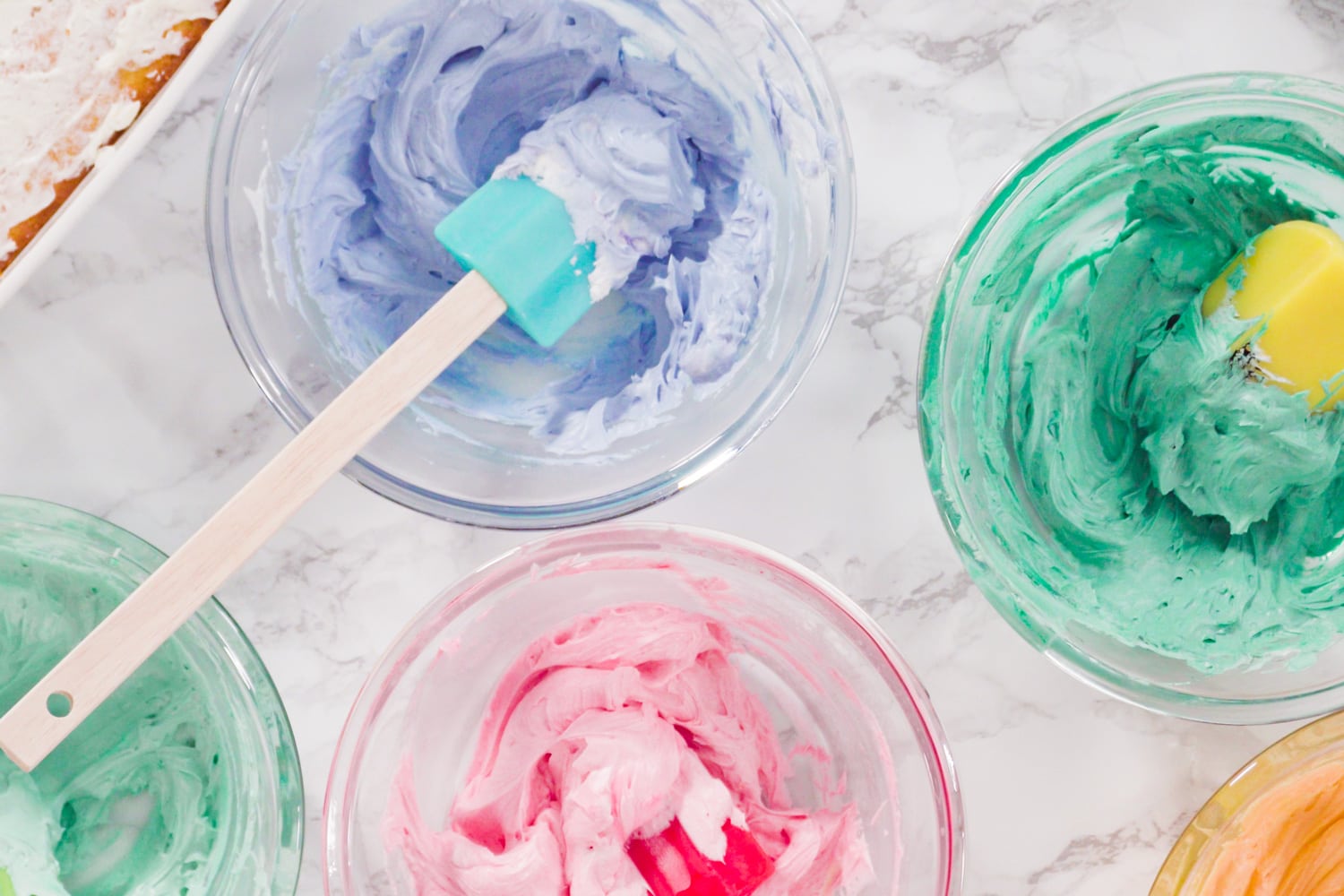 Mixing food coloring into Italian buttercream frosting.