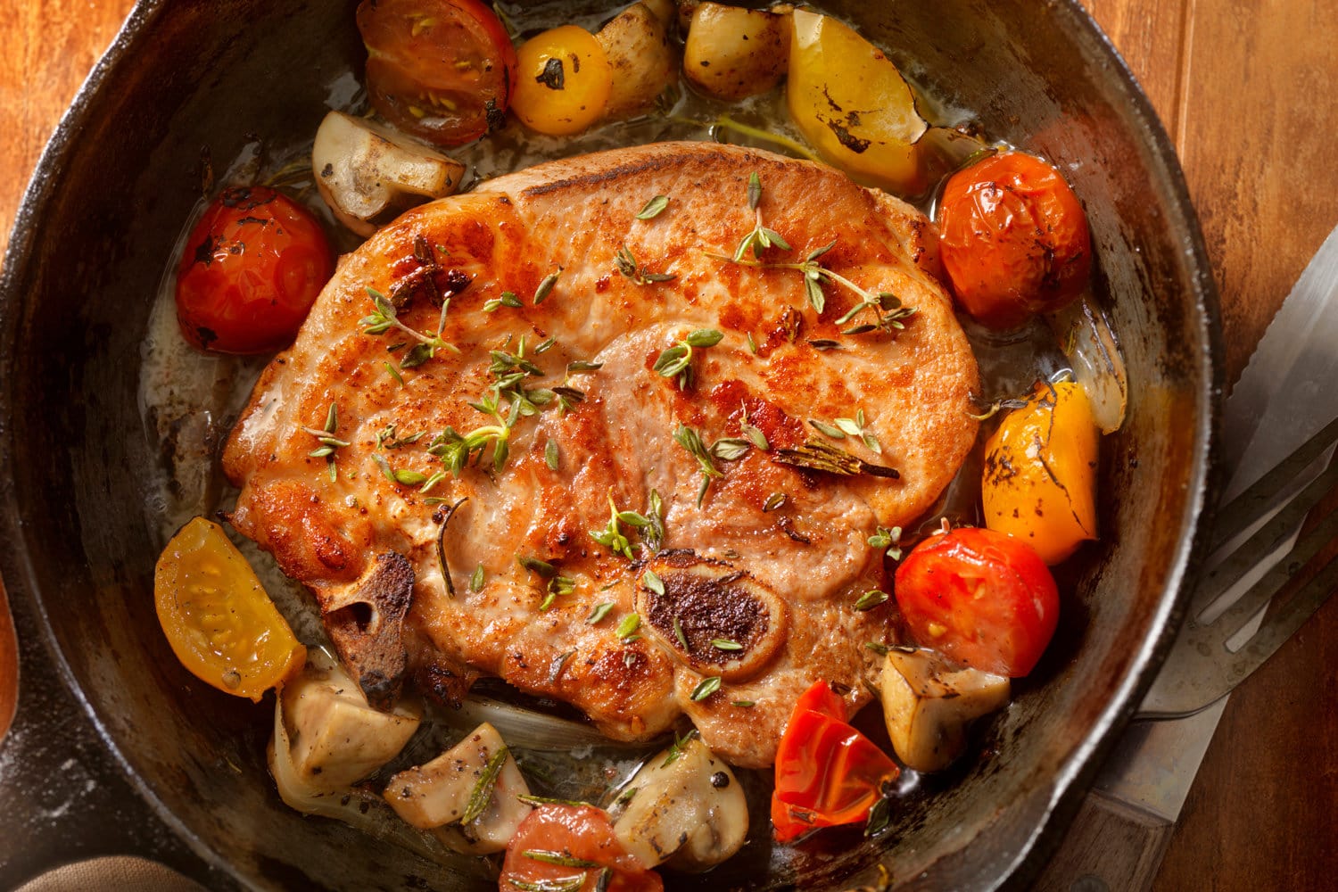 Pork Loin Chops with Tomatoes and Mushrooms in a Cast Iron Skillet