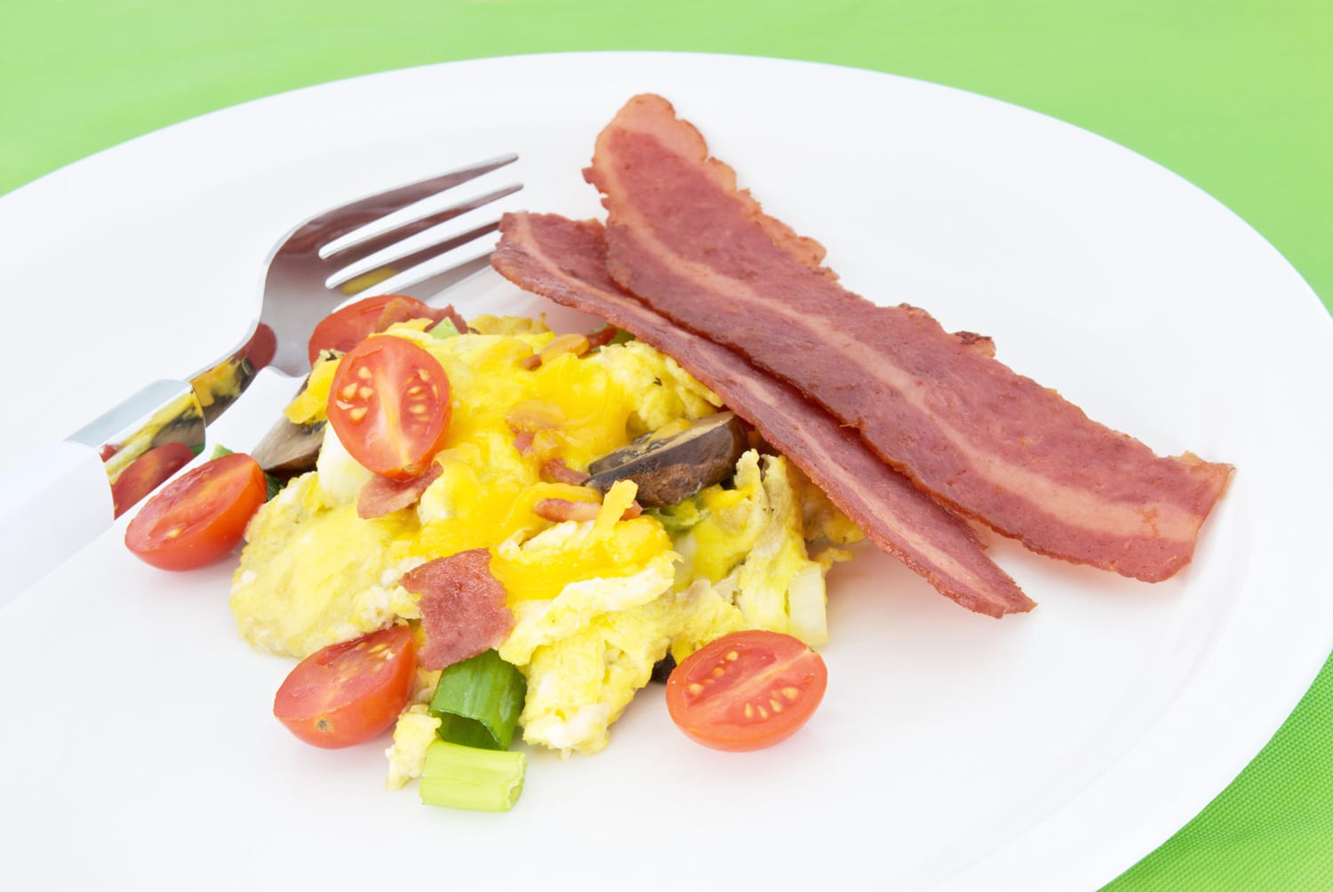 Scrambled egg served with two sliced of fried turkey bacon