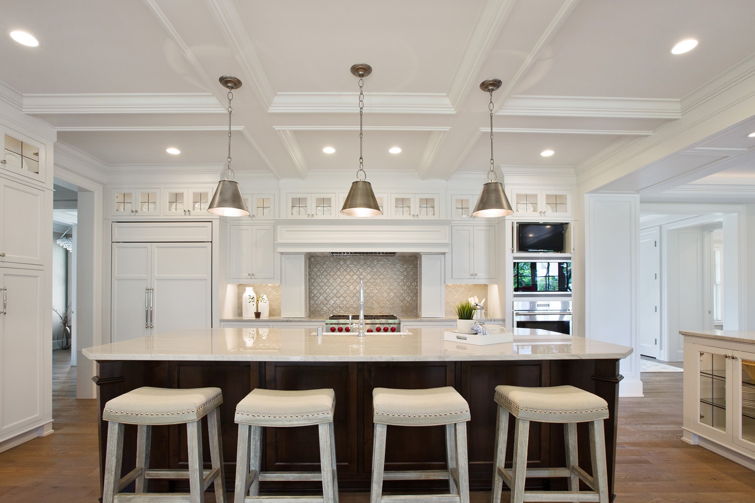 White kitchen with brown island and coffered ceiling