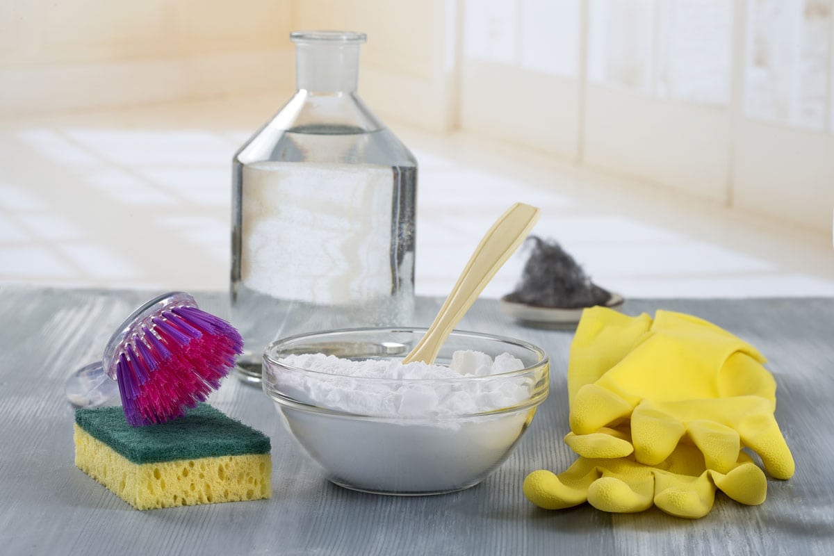Baking soda and other cleaning essentials on a table