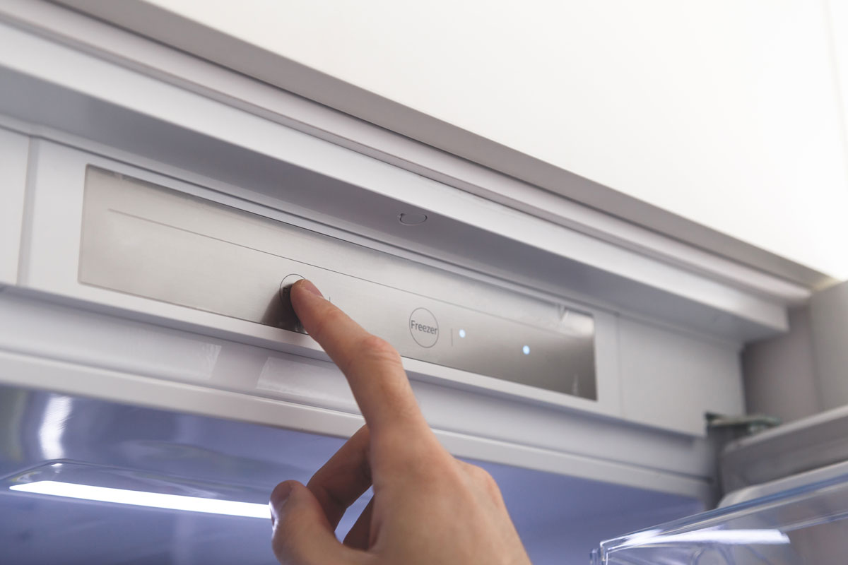 Man changing the refrigerator temperature setting