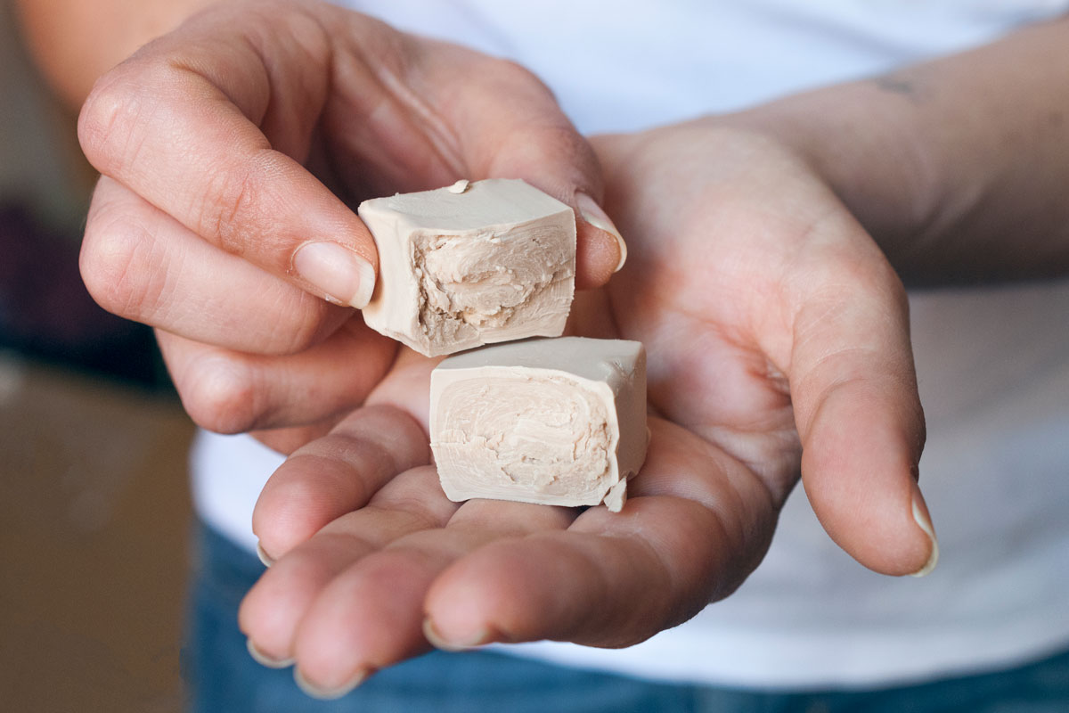 Man holding small cubes of yeast