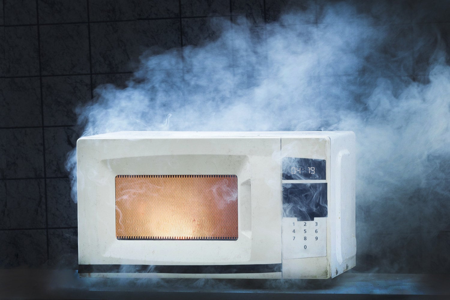 Microwave oven white, in fire front view, electrical appliances caught fire as a result of improper operation