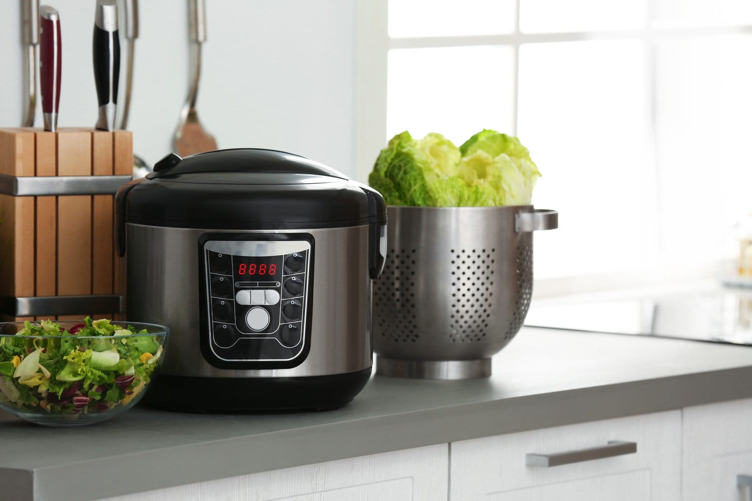 Modern electric multi cooker and food on kitchen countertop