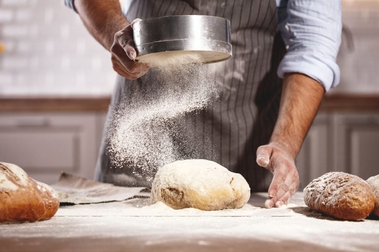 Pastry chef adding more flour to shape the dough, Dough Is Too Wet—What To Do?