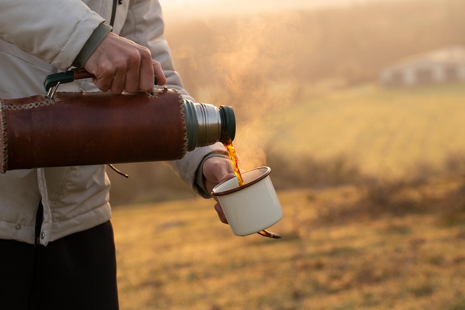 Pouring mug of coffee from a hot thermos