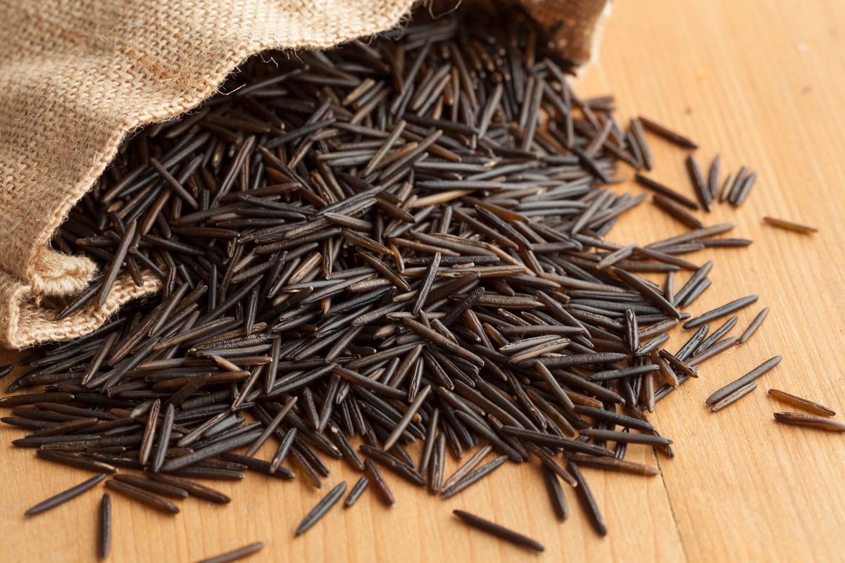 Raw black wild rice from a jute bag