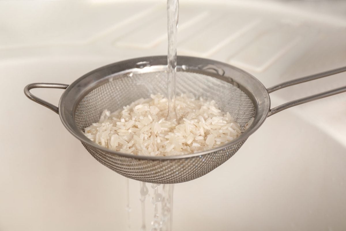 Rinsing rice under running water