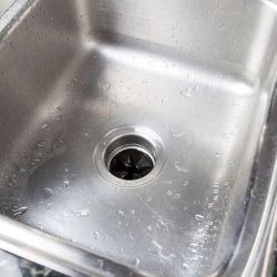 Stainless steal kitchen sink with water drops, What To Put Down A Garbage Disposal To Clean It [5 Suggestions]
