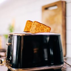Toast popping out of black toaster in kitchen, How To Clean A Toaster With Cheese In It