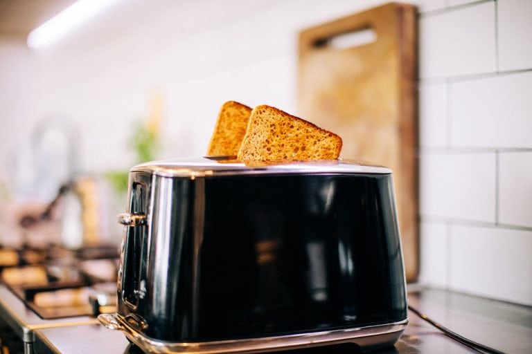 Toast popping out of black toaster in kitchen, How To Clean A Toaster With Cheese In It