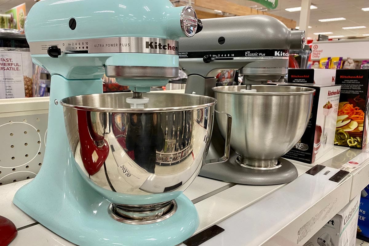 Two models of a KitchenAid food mixers on a store shelf