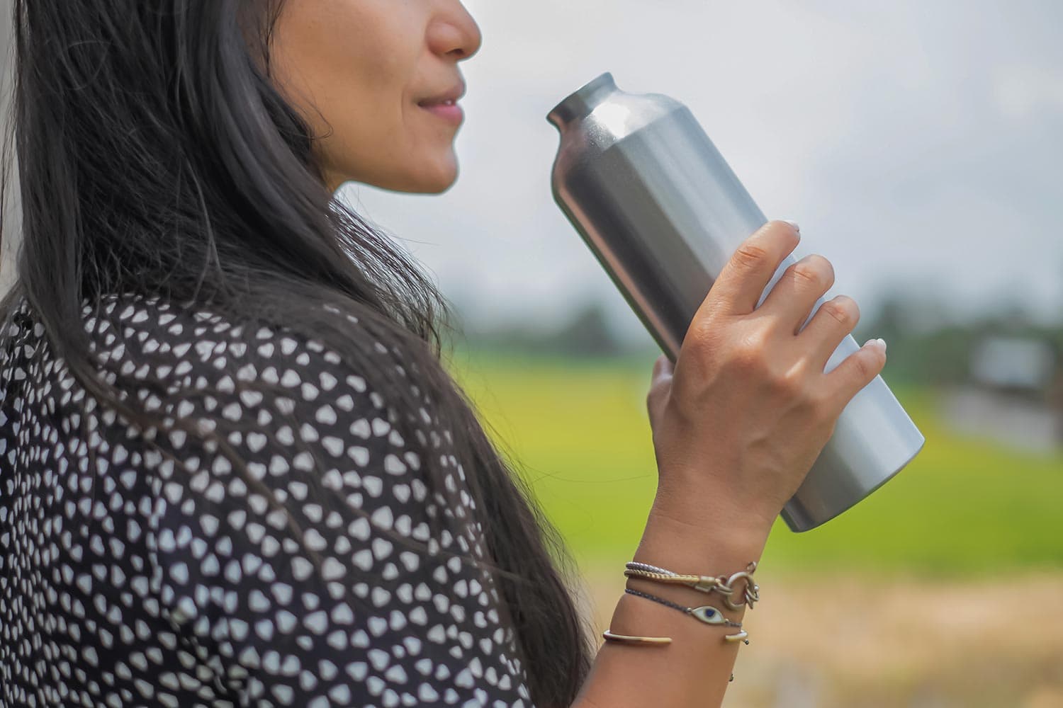 Woman drinking water from reusable water bottle