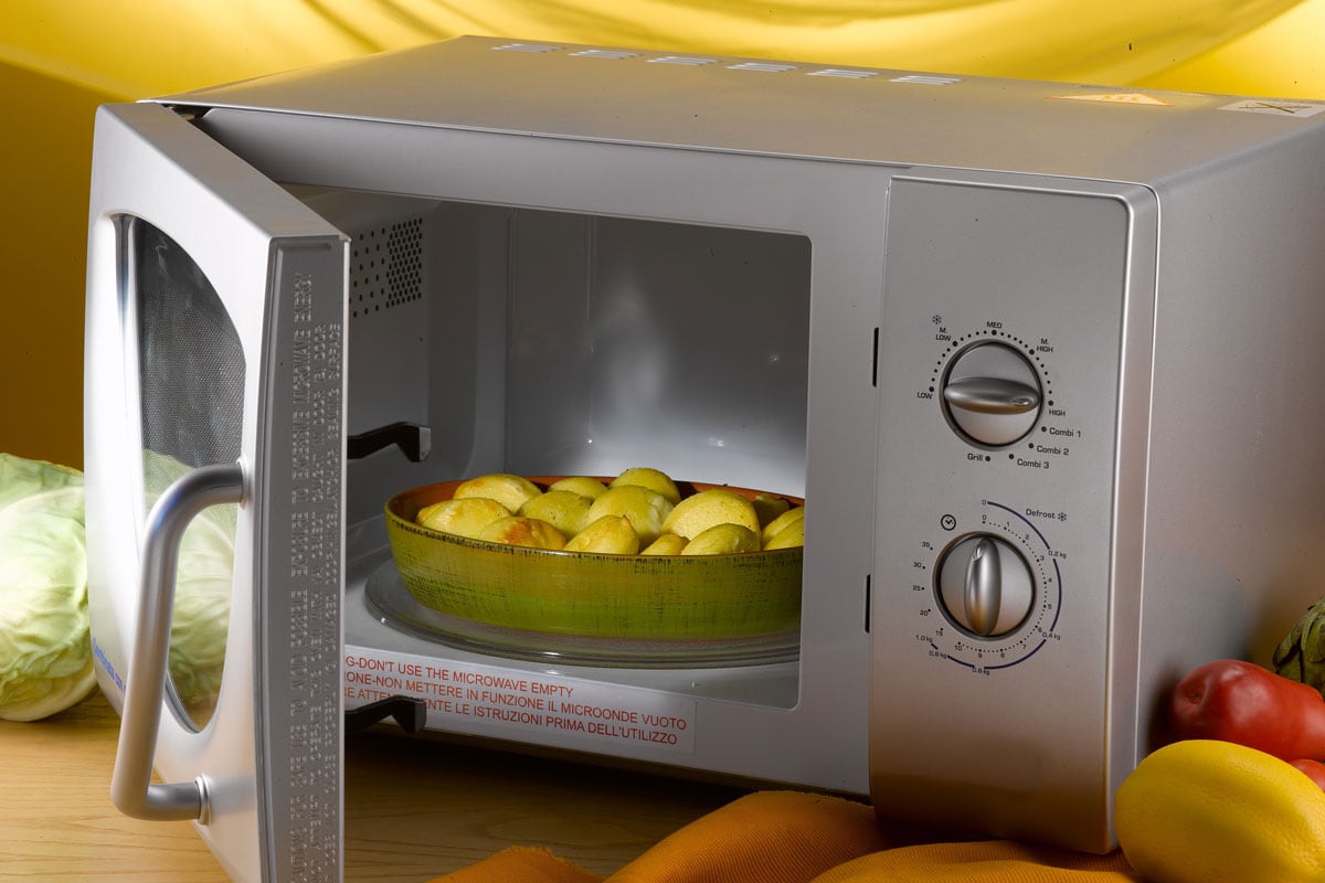 pan of baked potatoes into microwave oven