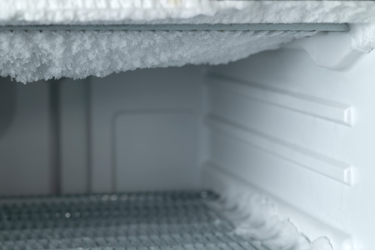 A small freezer with ice growing around it