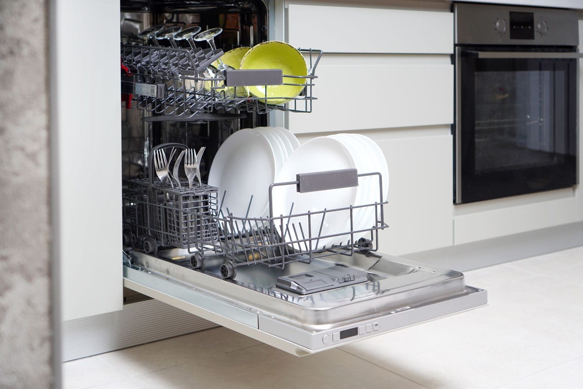 An opened dishwasher with lots of plates