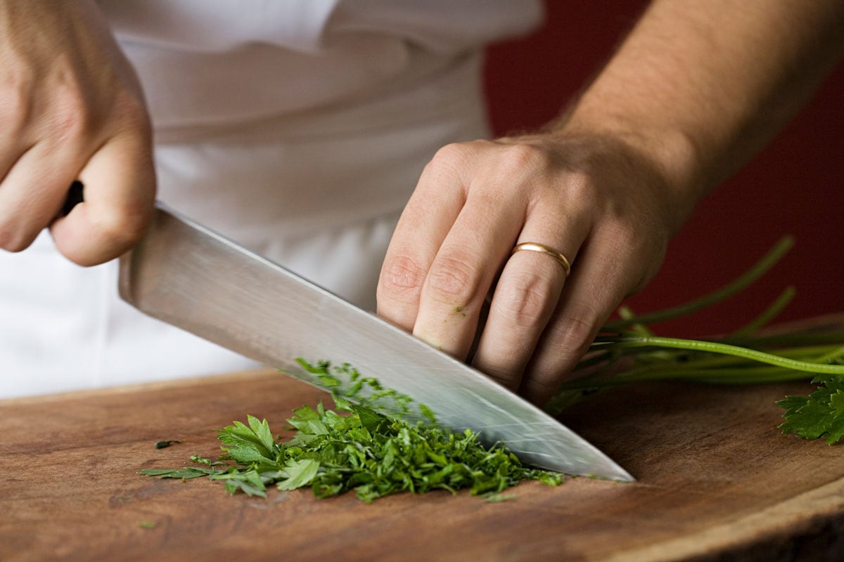 Chef cutting in parsley into pieces