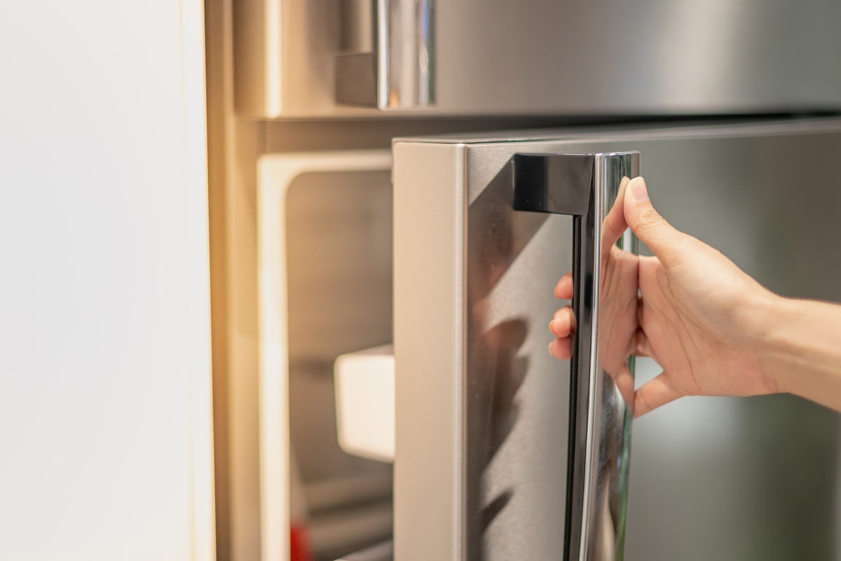 Female hand opening a refrigerator door for find the food and ingredient preparing to cooking in their home.