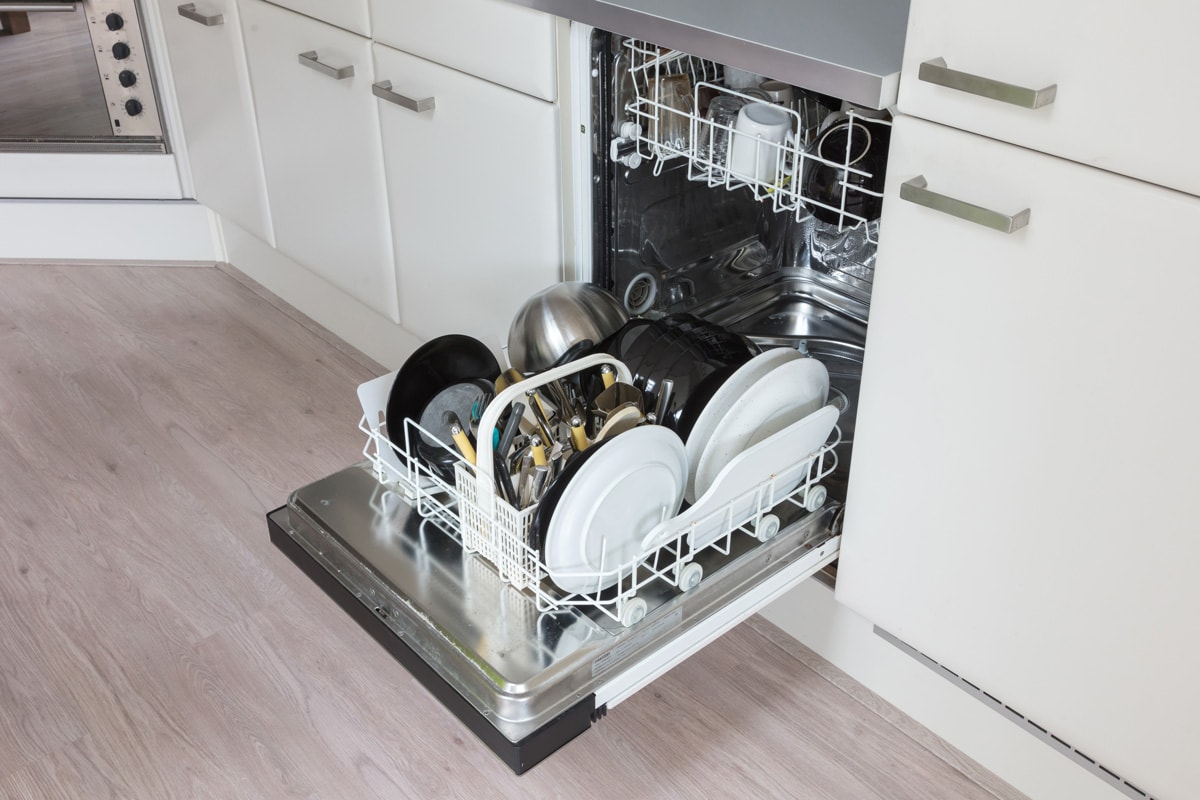 An opened dishwasher inside a modern kitchen