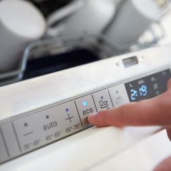Close Up Of Man Setting Economy Cycle On Dishwasher - How To Turn Off Sound On GE Dishwasher