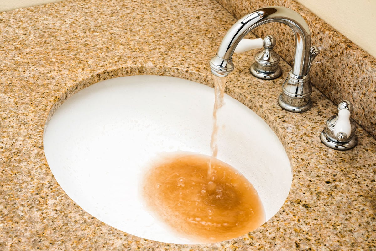 Dirty water pouring out of Vanity faucet into sink bowl
