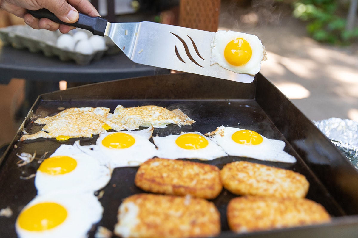 Frying eggs and burger patty on a blackstone griddle