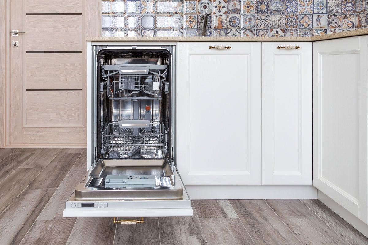 dishwasher with opened door in a white kitchen