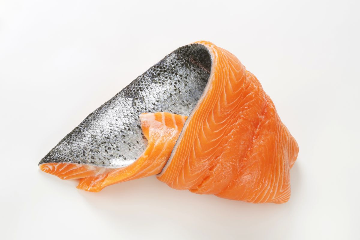 raw salmon fillet with silver skin on white background