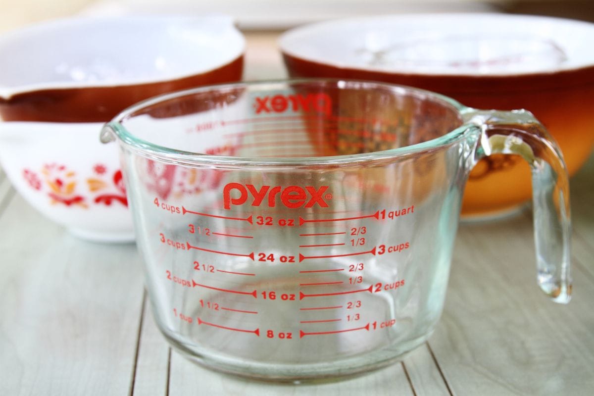 A PYREX clear glass measuring cup with several Pyrex mixing bowls in the background. Pyrex recently celebrated its 100th anniversary since it was introduced by Corning in 1915. The brand is now produced by World Kitchen LLC, a Corning spinoff.