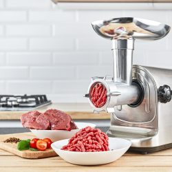 Bowl of mince with electric meat grinder in kitchen interior, Meat Grinder Keeps Clogging - Why And How To Fix It?