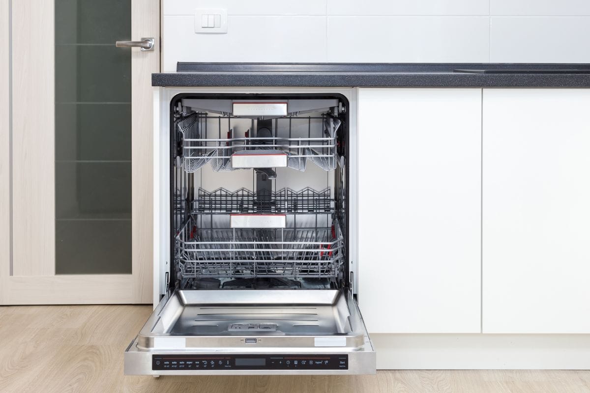 Open door of built-in dishwasher. Kitchen with integrated appliances. Plates and dishes in the dishwasher. How To Turn Off Child Lock On LG Dishwasher