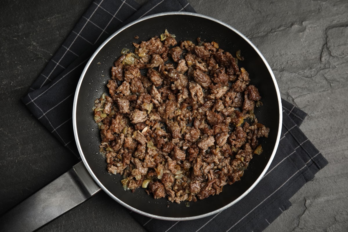 Fried minced meat with onion on black table, top view