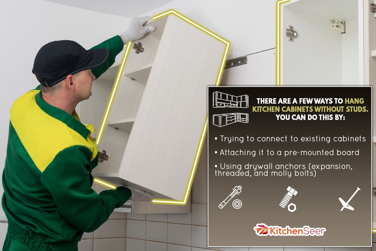 A worker hangs a kitchen cabinet on the wall, How To Hang Kitchen Cabinets Without Studs