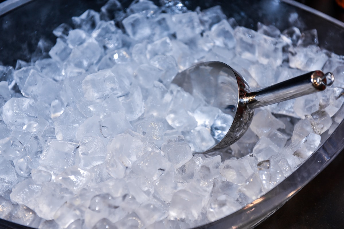 Ice in Ice Bucket with cool, iced scoop preparation of ice in a bar for event party