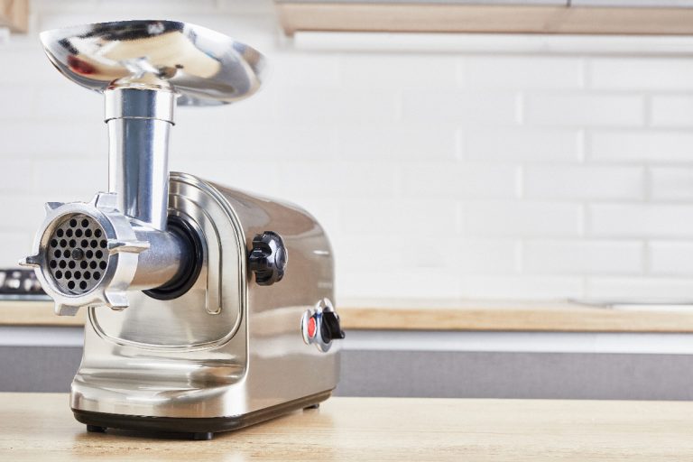 A meat grinder on a wooden table in kitchen, Can You Use A Meat Grinder To Rice Potatoes?