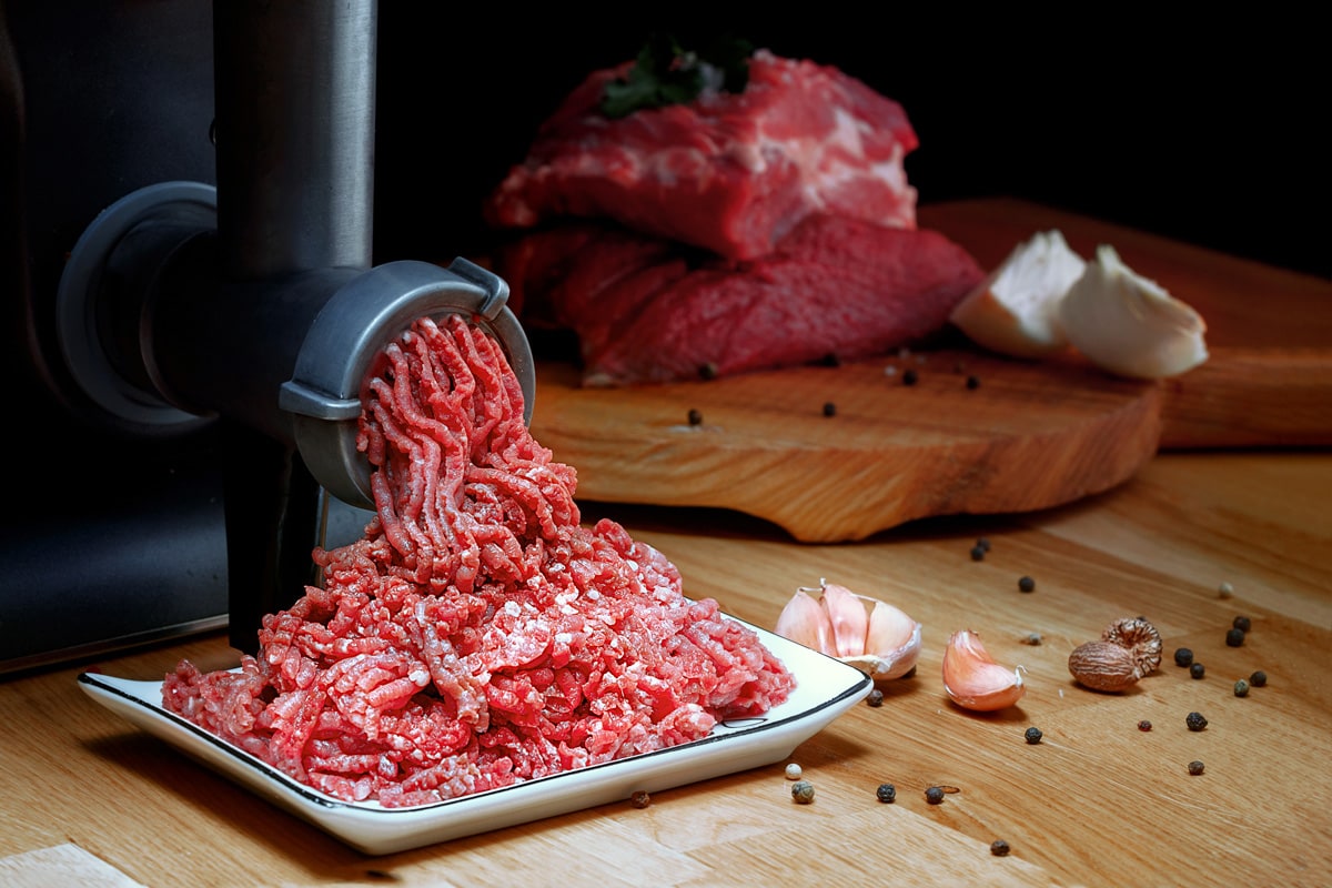 Minced meat coming out from grinder.