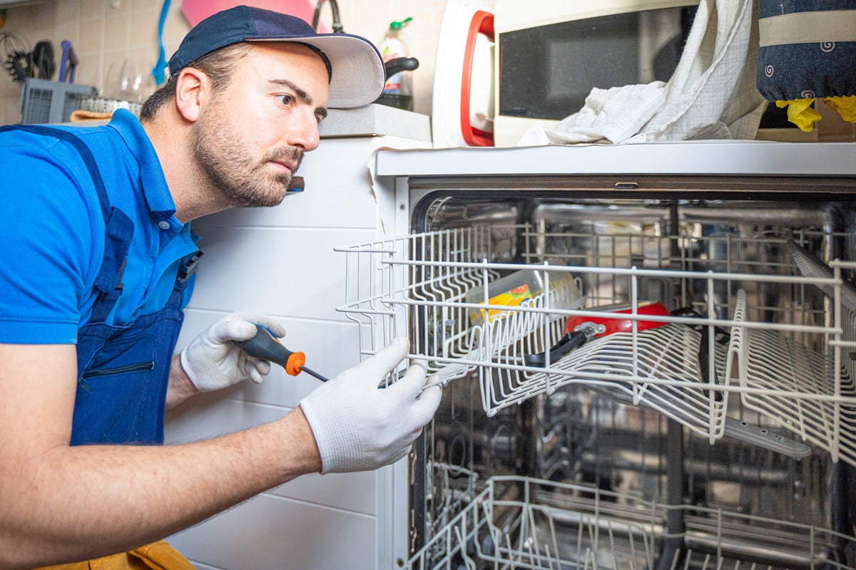 One repairman fixing malfunctioning kitchen dishwasher problem