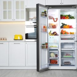 Open refrigerator filled with food in kitchen - Freon Leak In Refrigerator - Is It Dangerous? What To Do