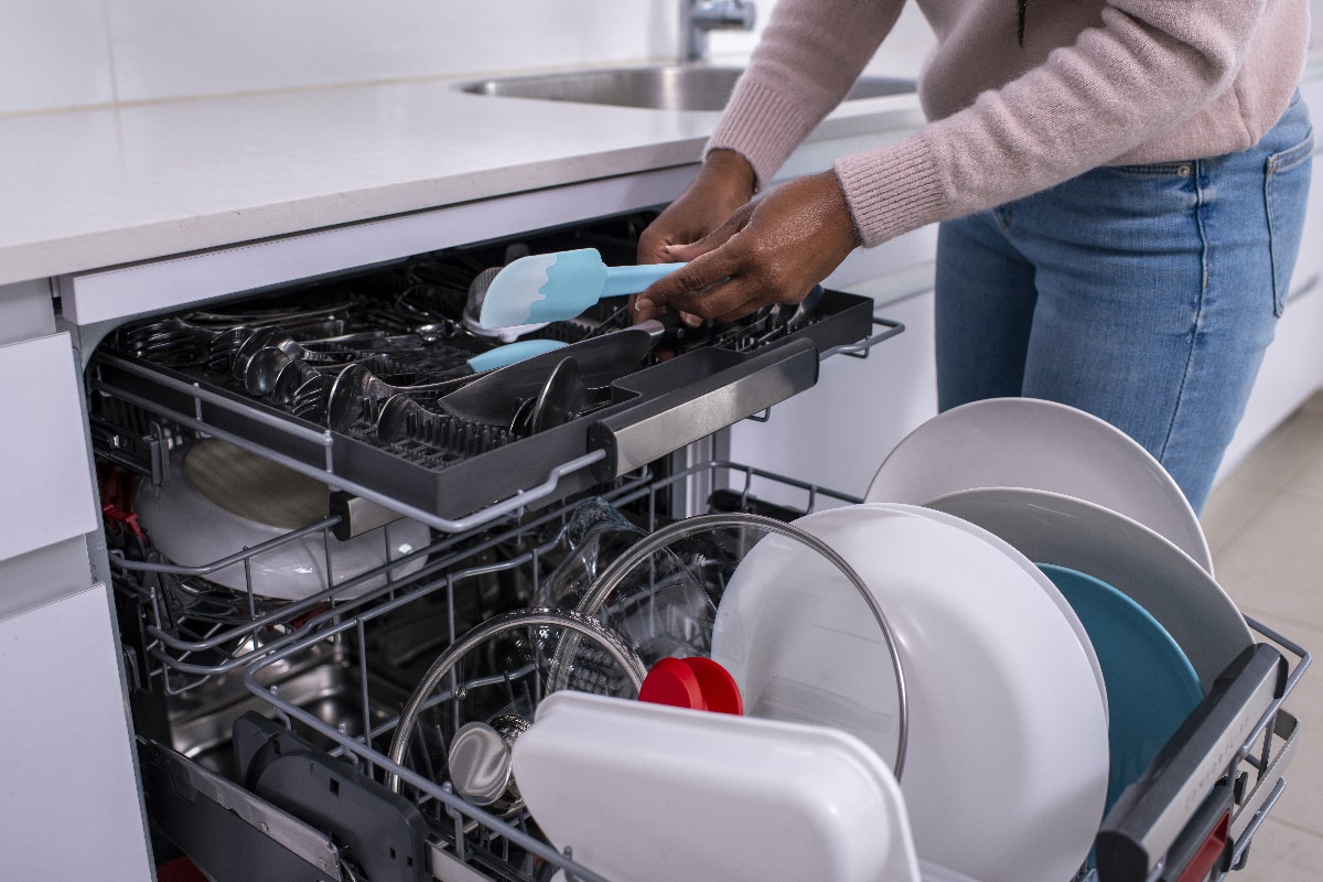 Woman unloading dishwasher after washing