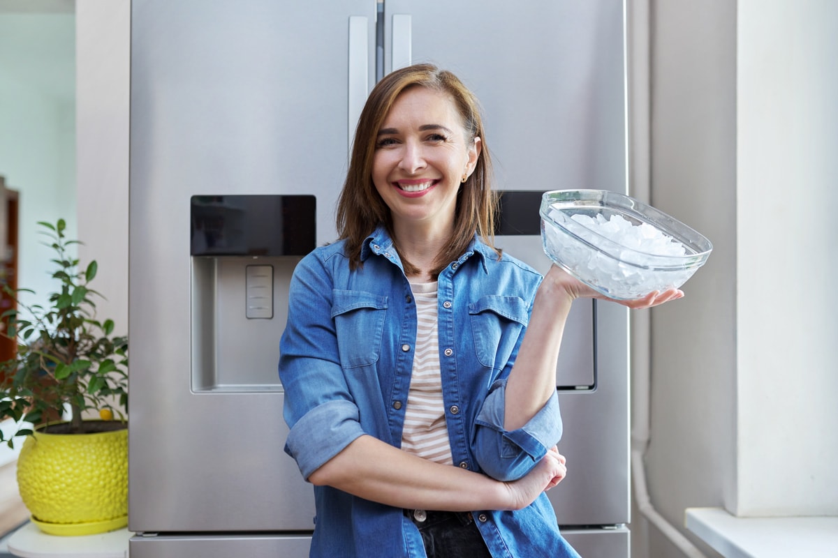 Woman with bowl with ice cubes for cooling food
