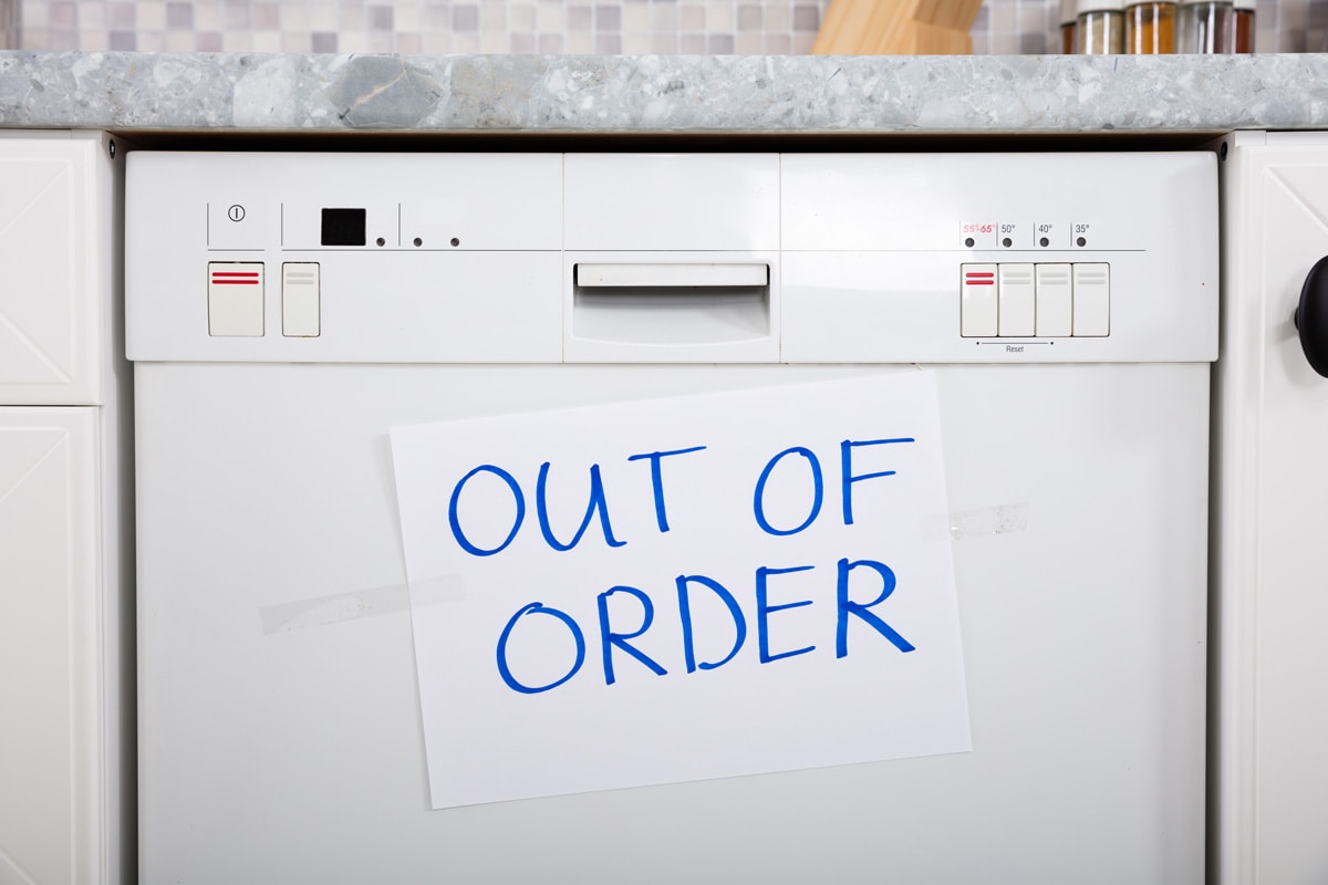 Written Text Out Of Order Message On Paper Over The Stuck Dishwasher In Kitchen