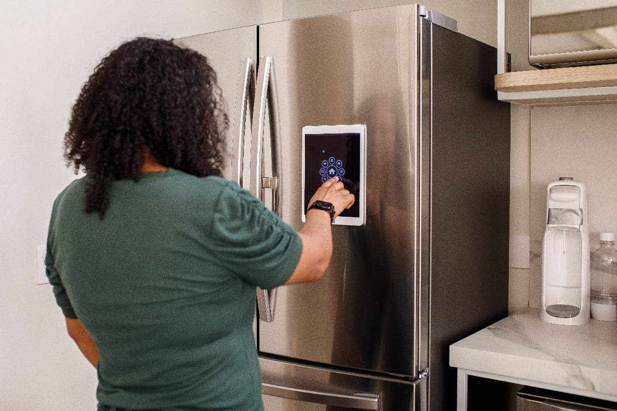 Young woman checking information from smart fridge