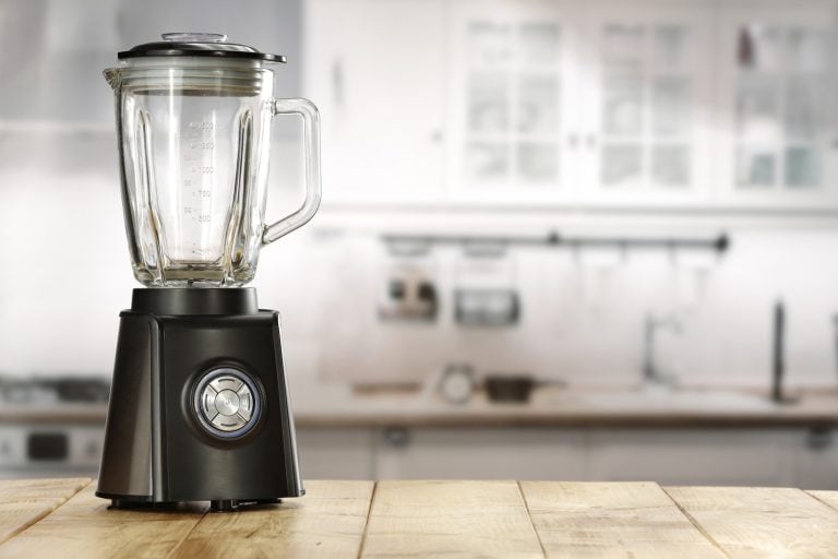blender and wooden table in kitchen - What Are The Best Blenders For Grinding Grains