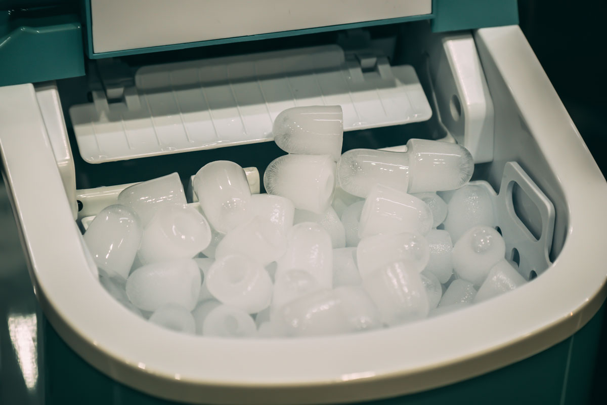 close up photo of a portable-mini-ice-cube-maker many ice cubes green colored ice maker portable