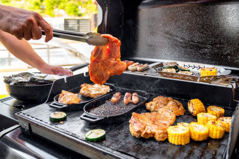 man is making grill barbecue outdoors on the backyard, beef steak and chopped corn, Can A Blackstone Griddle Be Built Into An Outdoor Kitchen?