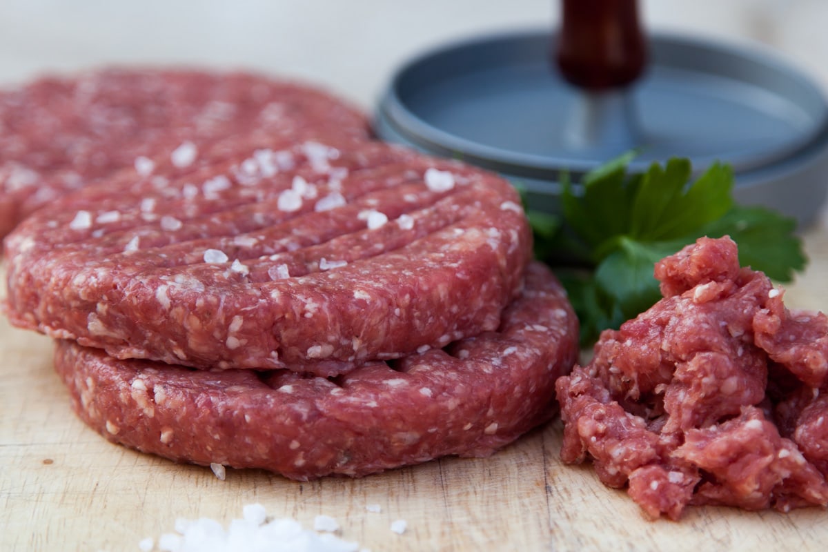raw beef burger with parsley and mould background