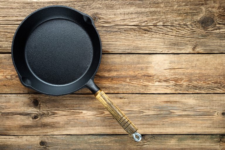A black non stick frying pan on a table, Stone Cookware Pros, Cons, & Considerations For Your Kitchen