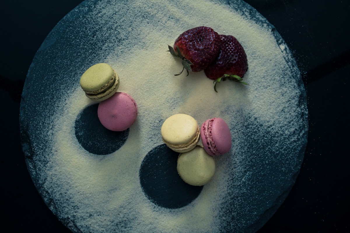 Assorted flavoured macaroons on a black slate board with strawberries , Can You Make Macarons Without Cream of Tartar?
