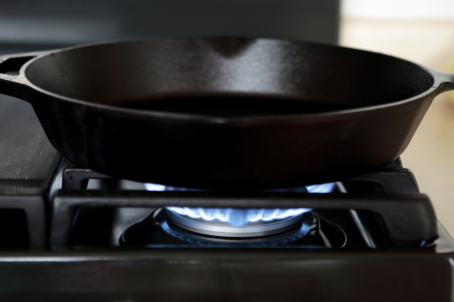Cast iron pan heating up on gas range stove.